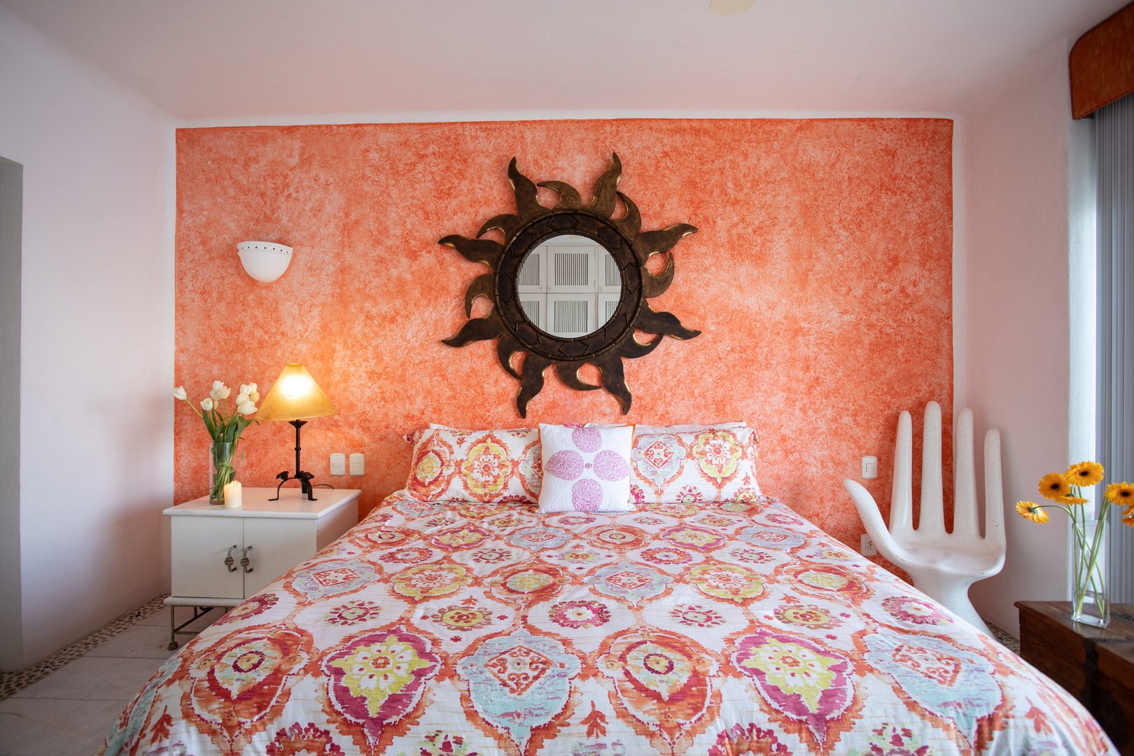 Colorful bedroom with sunburst mirror