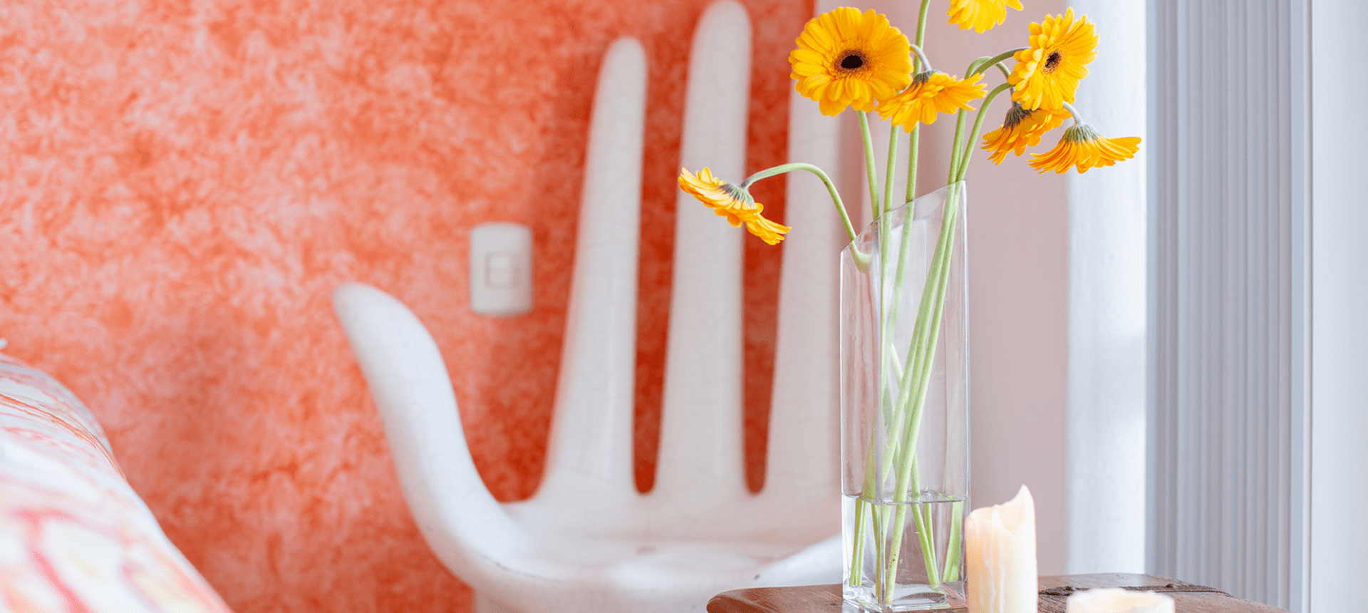 Yellow flowers in vase, orange wall background