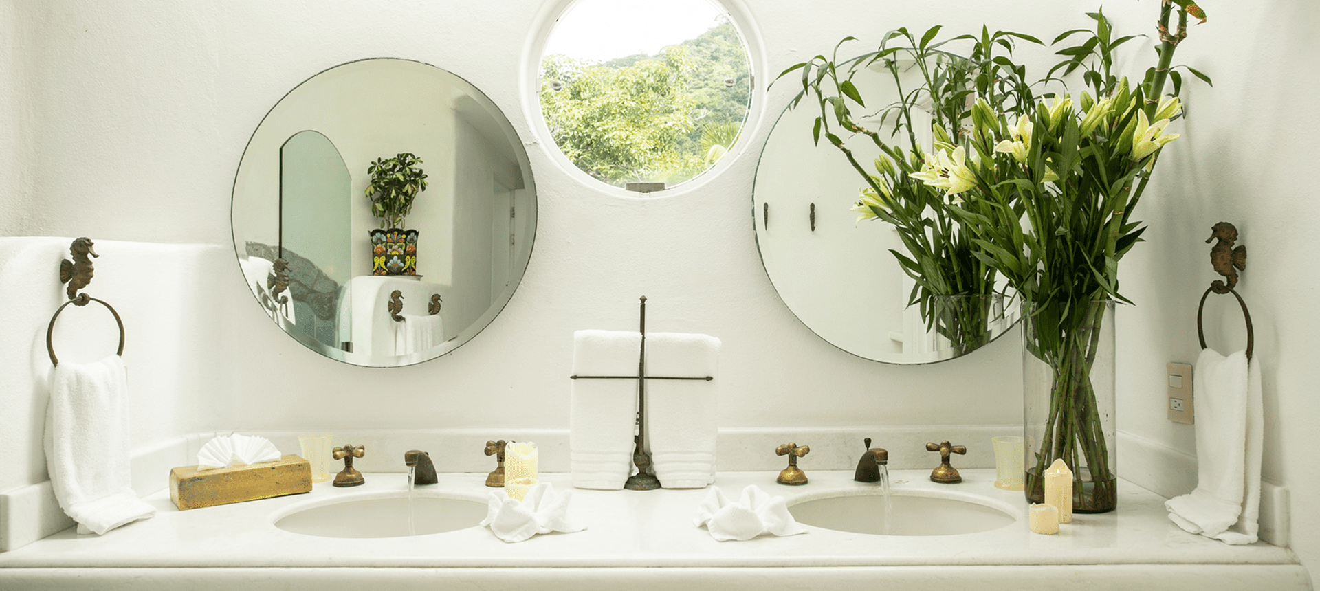 Elegant bathroom with round mirrors and flowers