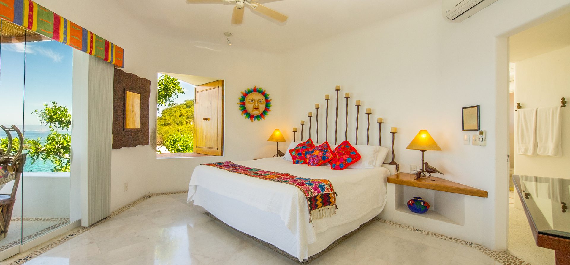 Bright bedroom with colorful decor and open window view.