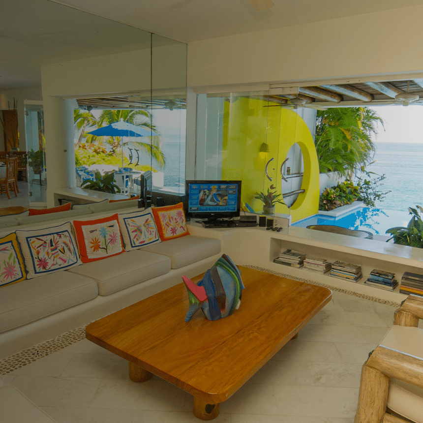 Cozy living room with a surfboard and ocean view.